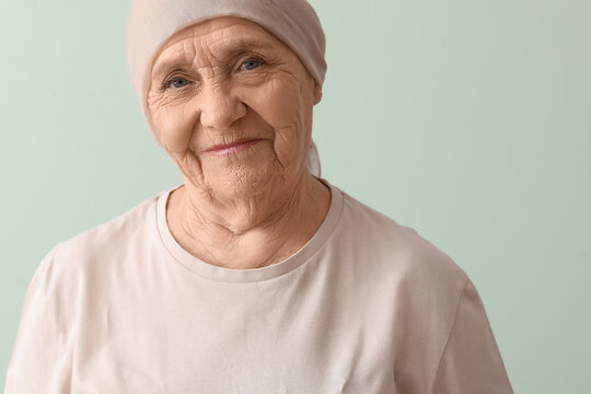 Senior woman after chemotherapy on green background, closeup