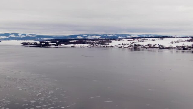 Soft aerial drift over Norwegian icy waters on cold wintery day