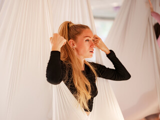 workshop of air yoga and stretching in yoga studio. women practices different inversion antigravity...
