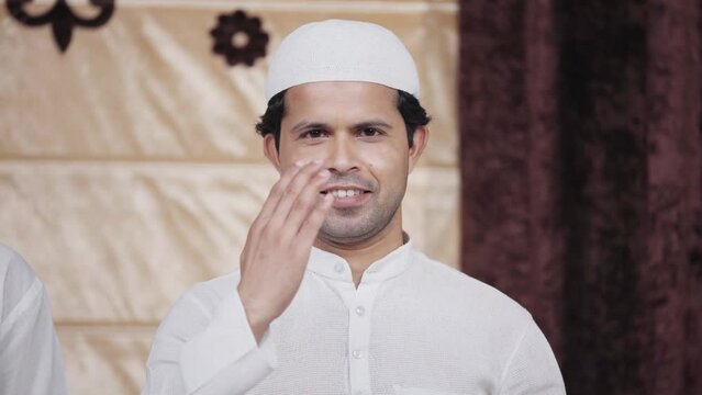 Indian man greeting by adab and smiling to the camera