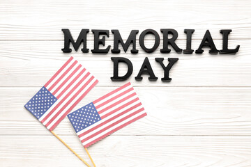 Text MEMORIAL DAY and USA flags on white wooden background
