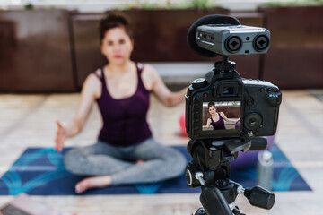 Latin woman recording workout exercise with video camera in terrace at home in Mexico, hispanic people