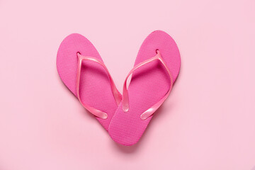 Flip-flops on pink background, top view