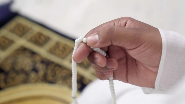 Muslim man praying beads to Allah