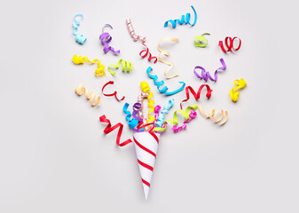 Party cone with serpentine on light background