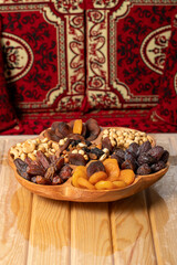Mixed nuts platter. Wood nut plate prepared with hazelnuts, cashews, dates, apricots and grapes.