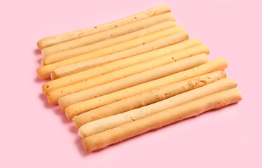 Tasty Italian Grissini on pink background