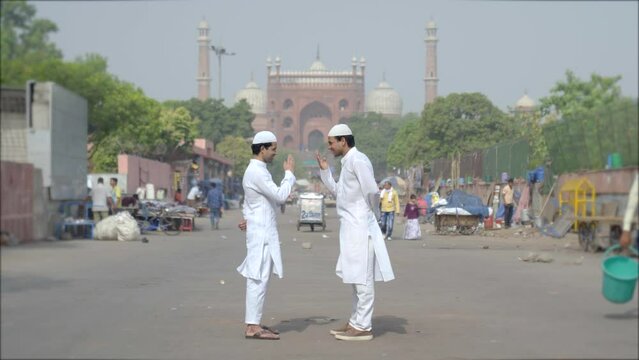 Two happy Indian muslim men greeting each other by Adab