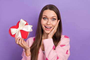 Portrait of funny surprised girl brown hair young hold her international woman day heart shape giftbox touch cheek isolated on purple background