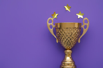 Gold cup with stars on purple background, closeup