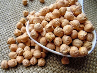 chickpeas on a spoon against a background of coarse cloth