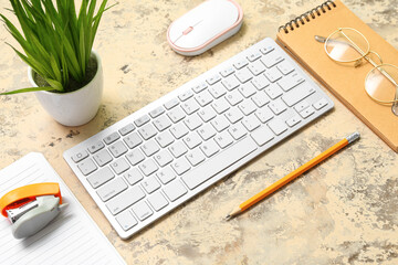Composition with keyboard, plant, eyeglasses and notepad on grunge background
