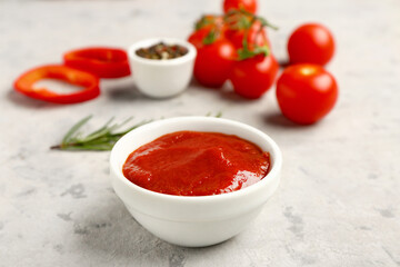 Bowl with tasty tomato paste on grunge background
