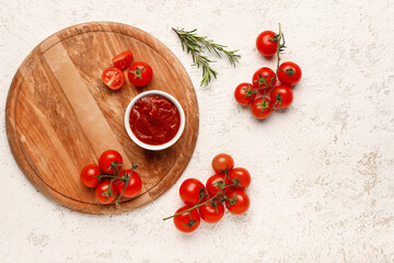 Bowl with tasty tomato paste and fresh vegetables on light background