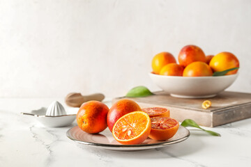 Plate with tasty blood oranges on light table