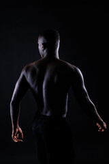 Fototapeta na wymiar Portrait of an athletic african american man topless, black background