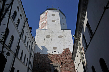 Tower and walls of the old castle in the city of Vyborg, Russia. Cityscape with ancient fortress on island is popular tourist destination and historic building landmark.