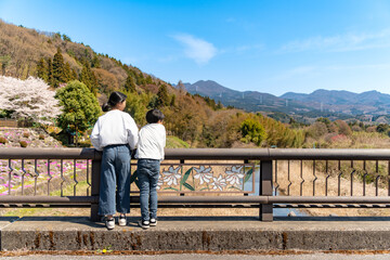 Fototapeta na wymiar 青空に映える田舎の風景を眺める子供