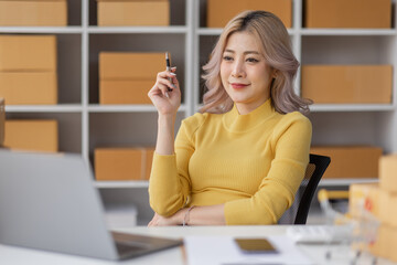 Portrait of Asian young woman SME working with a box at home the workplace.start-up small business owner, small business entrepreneur SME or freelance business online and delivery concept.
