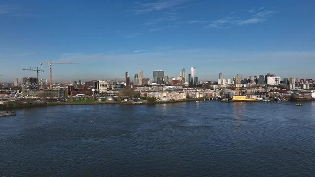 Panoramic drone push-in over New Meuse river with Rotterdam skyline view
