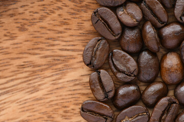 Coffee beans isolated on wooden background.