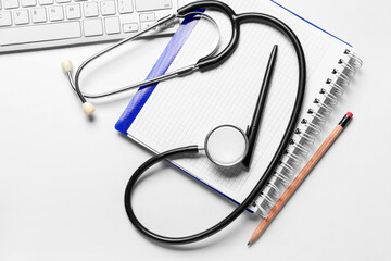 Stethoscope, notebook and pc keyboard on doctor's table
