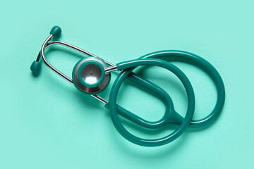 Modern stethoscope on turquoise background