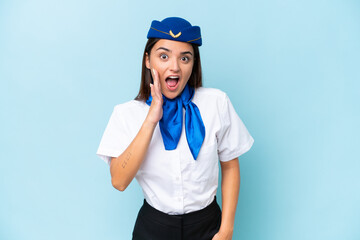 Airplane stewardess caucasian woman isolated on blue background with surprise and shocked facial expression