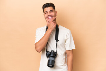 Young photographer caucasian man isolated on beige background smiling