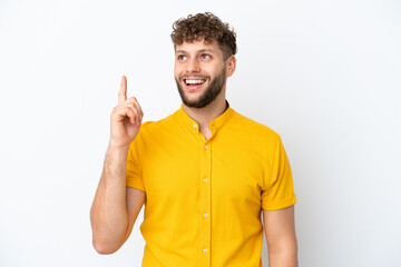 Naklejka premium Young handsome caucasian man isolated on white background pointing up and surprised