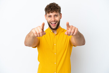 Young handsome caucasian man isolated on white background surprised and pointing front