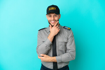 Young security man isolated on blue background smiling