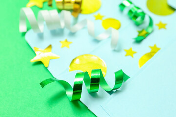 Composition with envelope and confetti on green background