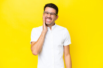 Young handsome man over isolated yellow background with toothache