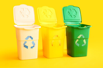 Containers for garbage on yellow background. Recycling concept