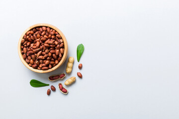 Fresh healthy peanuts in bowl on colored table background. Top view Healthy eating bertholletia concept. Super foods