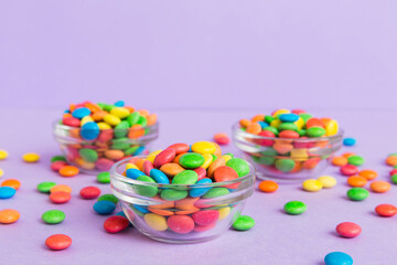 Multicolored candies in a bowl on a colored background. birthday and holiday concept. Top view with copy space