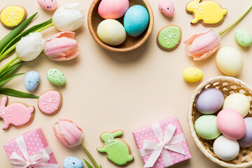 Easter frame with eggs, gift box and tulip on a colored background. The minimal concept. Top view Happy Easter composition. Card with a copy space of the place for the text