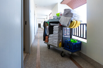 The hotel cleaning tool cart of housekeeper are on the walkway of resort area. Cleaners trolley on floor of hotel. Cart for cleaning room in the hotel © kanpisut