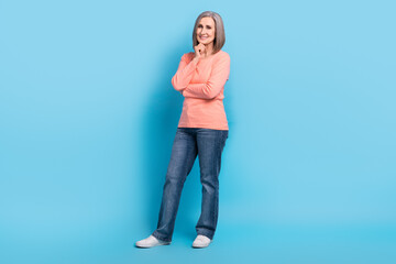 Full size photo of pleasant friendly smart grandmother dressed pink pullover jeans finger on chin isolated on blue color background