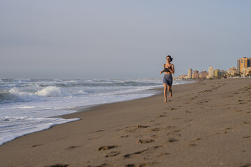 beautiful young girl running in the morning on the beach
