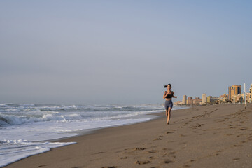 beautiful young girl running in the morning on the beach
