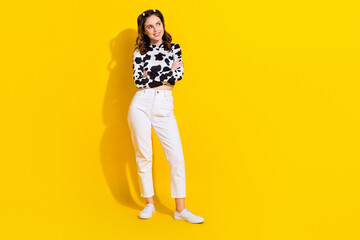 Fototapeta premium Full length photo of funky dreamy lady dressed cowskin shirt arms folded looking empty space isolated yellow color background