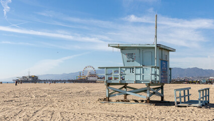 Fototapeta na wymiar A lifeguard tower on Santa Monica beach with pier in the background located in California USA taken on February 5th 2023