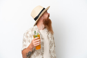 Redhead man with long beard drinking a cocktail on a beach isolated on white background laughing in...