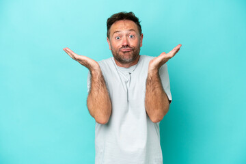 Middle age caucasian man isolated on blue background making doubts gesture