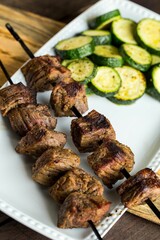 Closeup of a Steak Shish Kababb with a barbecued zucchini side dish