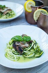 High angle closeup of a chicken on zucchini meal