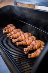 Grill with chicken legs wrapped in bacon