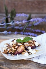 Plate with burger salad with various ingredients on a wooden table